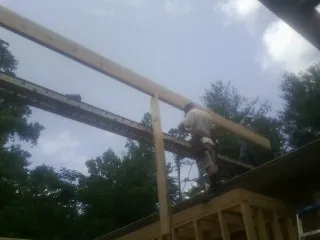 Carpenter setting a ridge beam over a new addition frame — Ice Dam Removal by Roofing Brothers in Londonderry