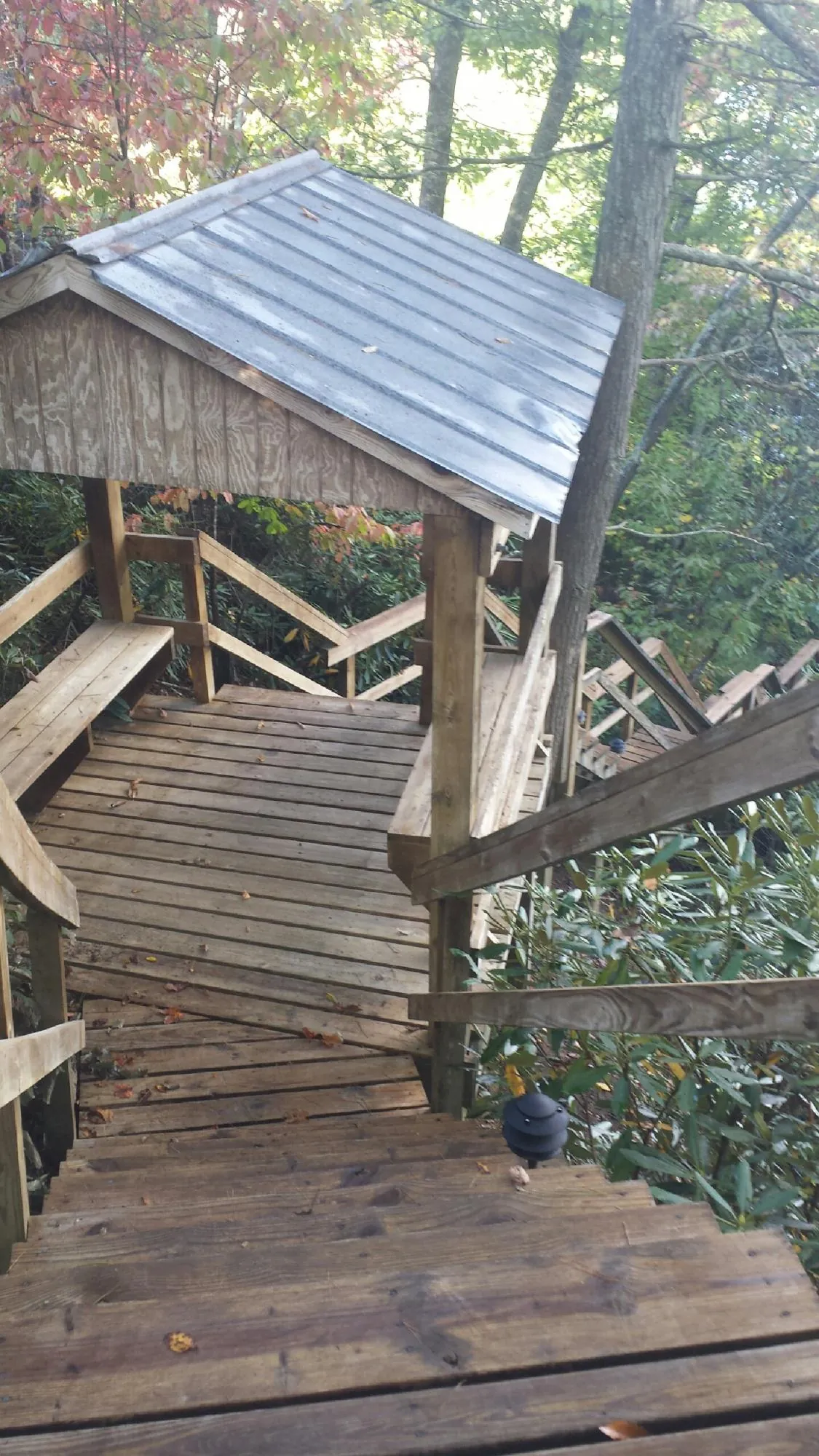Metal roofed shelter over wooden steps on a wooded walkway — Skylight Repair & Installation work by our crew in Londonderry