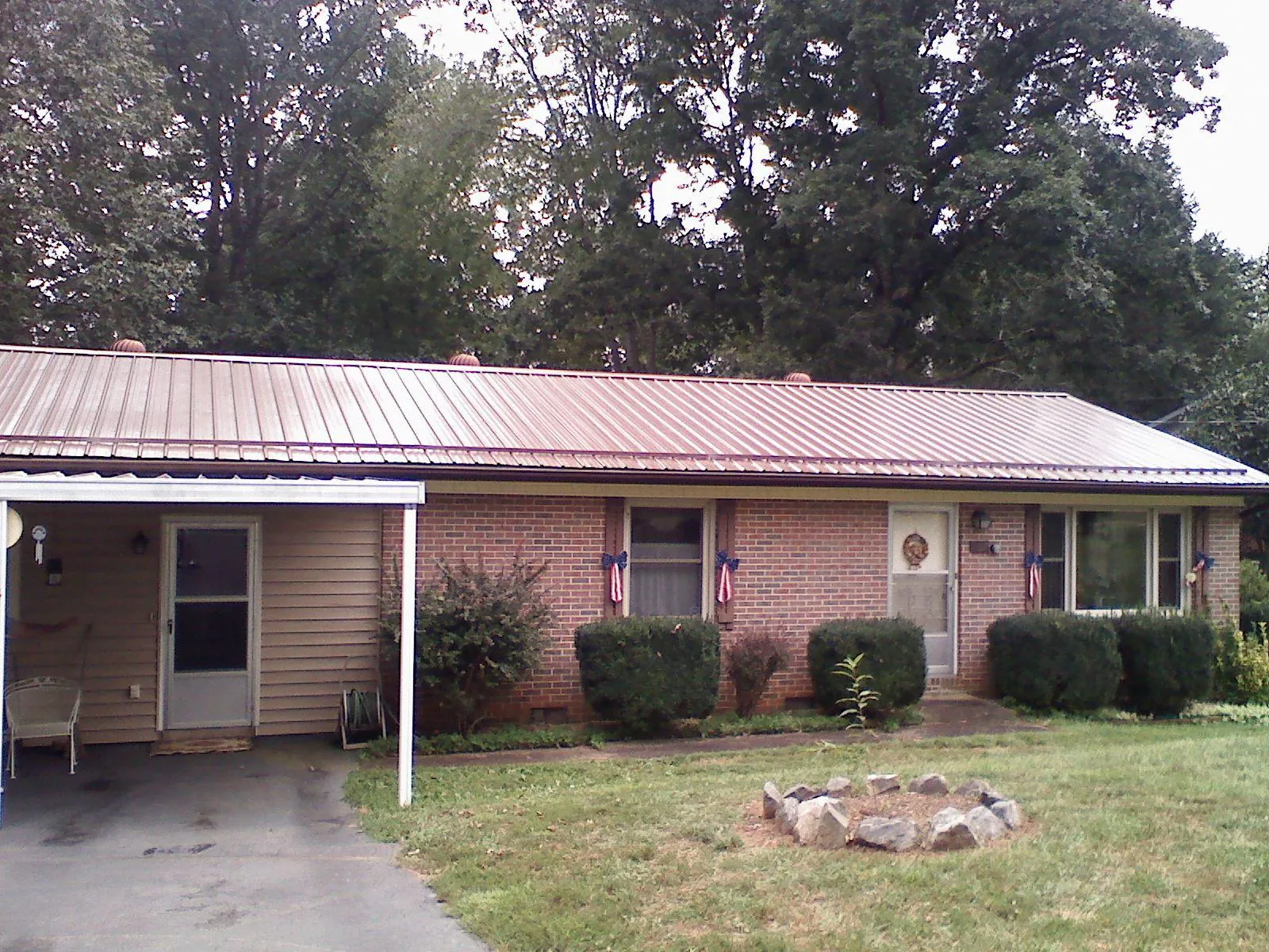 Bronze metal roof and carport on a brick ranch home — Roof Repair work by our crew in Londonderry